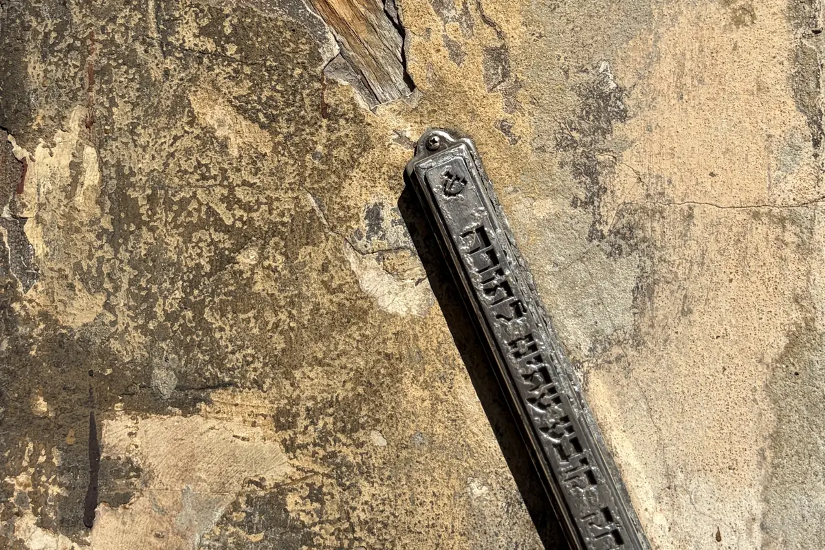 A preserved ornamental mezuzah on the damaged plaster of a door frame on Józefa St. in Kazimierz