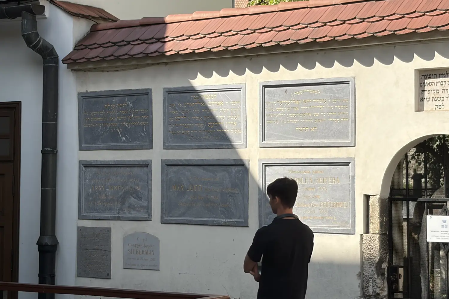A wall of memorial plaques by the Remah Cemetery in Kraków