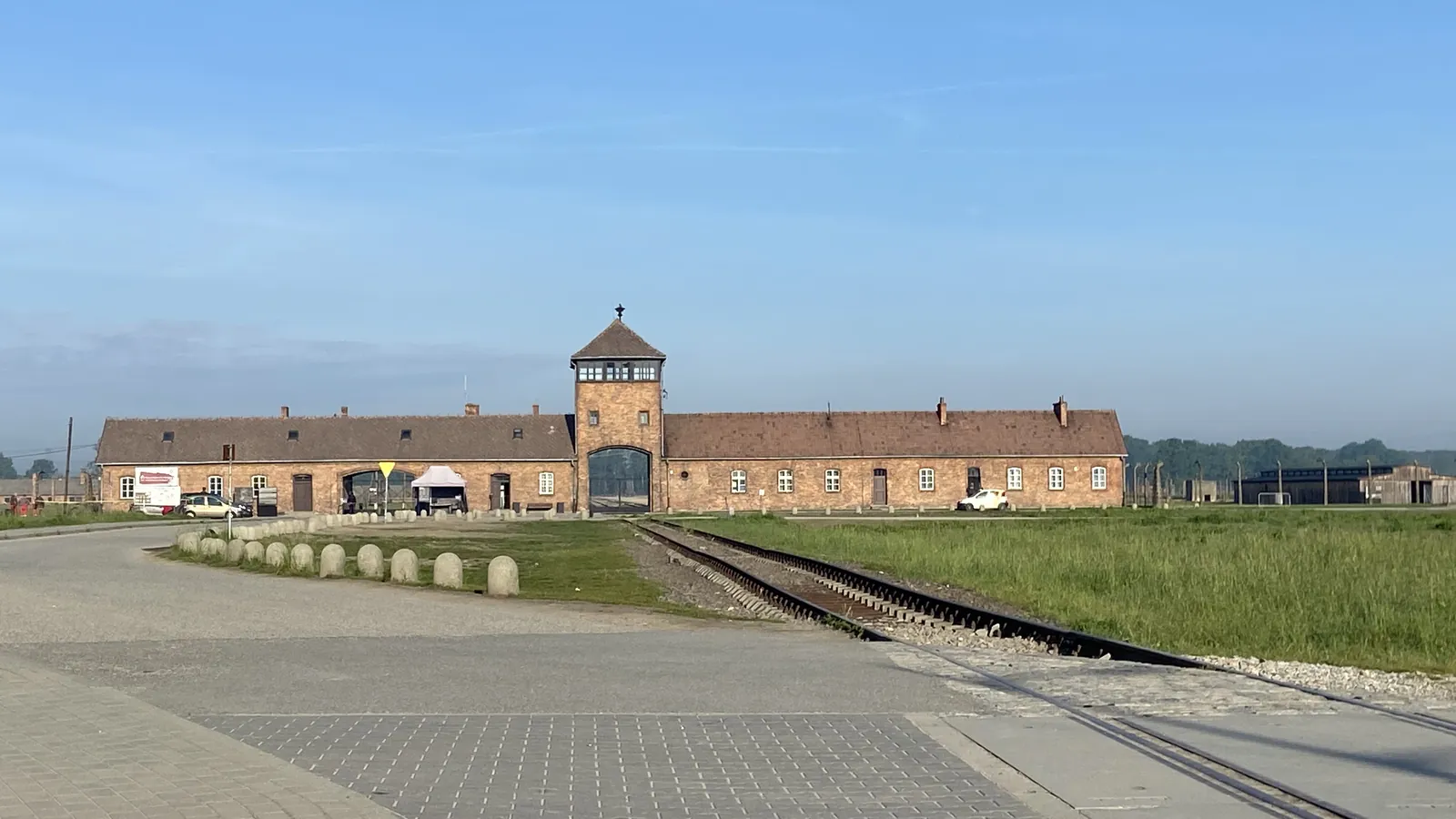 Main gate of the former German Nazi camp Auschwitz II-Birkenau in Oświęcim, with railway tracks